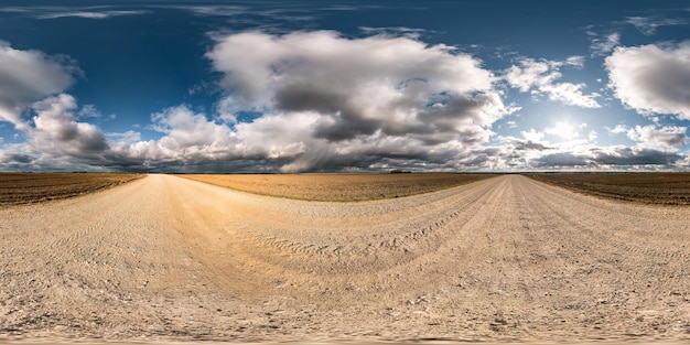 Panorama hdri sphérique complet et harmonieux à 360 degrés sur la route de gravier parmi les champs en automne avec de beaux nuages en projection équirectangulaire prêt pour le contenu de réalité virtuelle VR AR