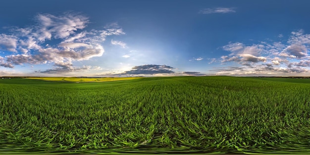 Panorama hdri sphérique complet et harmonieux vue à 360 degrés parmi les champs le soir du printemps avec des nuages impressionnants en projection équirectangulaire prêt pour le contenu de réalité virtuelle VR AR