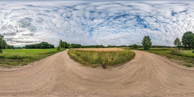 Panorama hdri sphérique complet sans couture Vue d'angle à 360 degrés parmi les champs au coucher du soleil d'été avec de beaux nuages en projection équirectangulaire