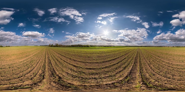 Panorama hdri sphérique harmonieux à 360 degrés sur les champs au printemps avec des nuages impressionnants en projection équirectangulaire prêt pour le contenu de réalité virtuelle VR AR