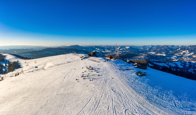 Panorama d'hiver des pentes enneigées dans une station de ski en Europe sur une journée glaciale ensoleillée et sans vent