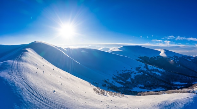 Panorama hivernal magique de belles pentes enneigées dans une station de ski en Europe par une journée glaciale ensoleillée et sans vent. Le concept de loisirs actifs en hiver