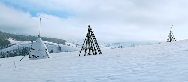 Panorama de montagne d'hiver avec botte de foin au premier plan