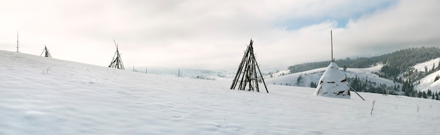 Panorama de montagne d'hiver avec botte de foin sur un premier plan (Village Slavske, région de Lviv, Ukraine). Sept clichés piquent l'image.