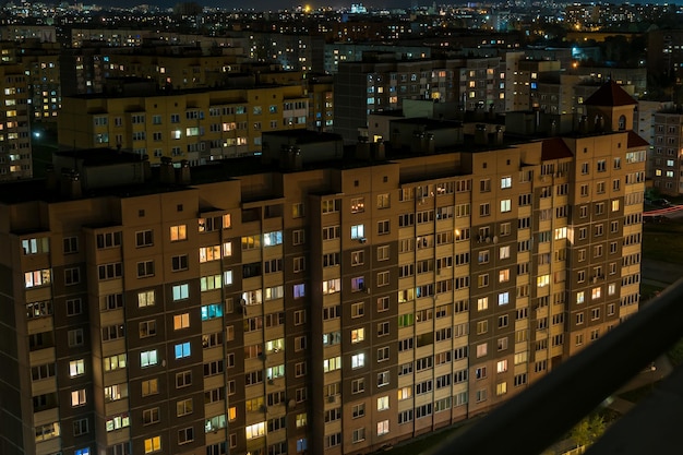 Photo panorama nocturne de la lumière dans les fenêtres d'un bâtiment à plusieurs étages dans une grande ville