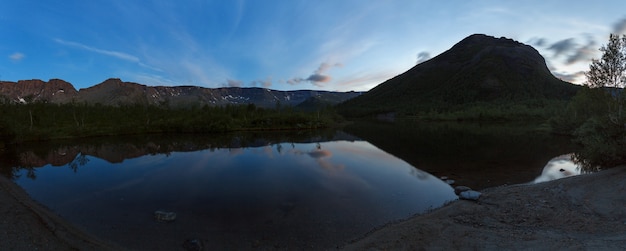 Panorama de nuit avec les montagnes du Khibiny, ciel reflété dans le lac Petit Vudyavr. Péninsule de Kola, Russie.