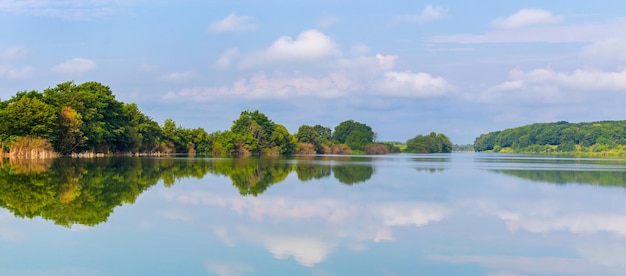 Panorama de paysage d'été avec rivière et arbres se reflétant dans l'eau de la rivière