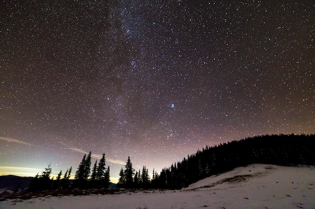 Panorama de paysage de montagne hiver nuit. Constellation lumineuse de la voie lactée dans le ciel étoilé bleu foncé