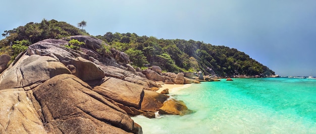 Panorama de la plage vide et préservée des îles Similan avec d'énormes rochers idylliques, un soleil doré, une forêt de jungle et une mer bleu turquoise prise le jour ensoleillé. Phang Nga, Thaïlande