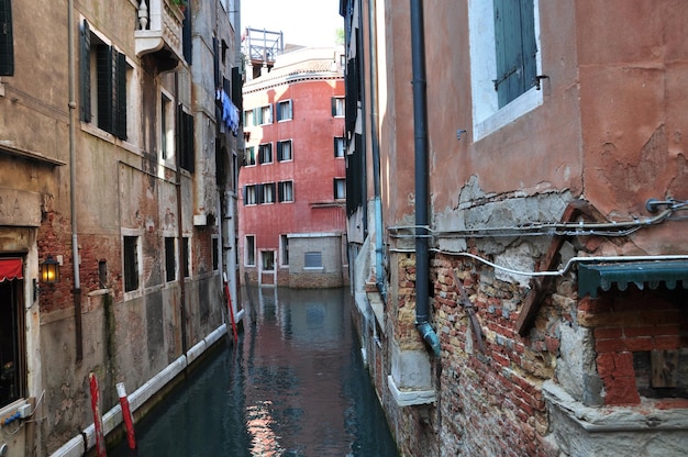 Panorama de la rue de Venise avec canal. Vue sur les vieilles maisons en briques de la ville. Le plâtre s'est envolé de la maison.