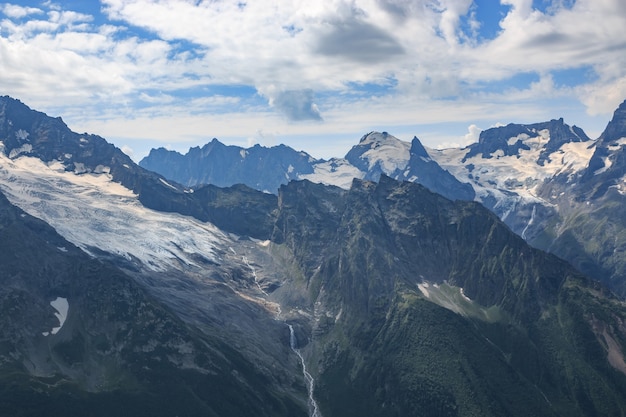 Panorama de la scène des montagnes avec un ciel bleu dramatique dans le parc national de Dombay, Caucase, Russie. Paysage d'été et journée ensoleillée