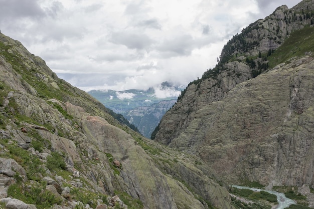 Panorama de la scène des montagnes sur la route du pont du Trift dans le parc national de la Suisse, de l'Europe. Ciel nuageux dramatique et paysage d'été ensoleillé