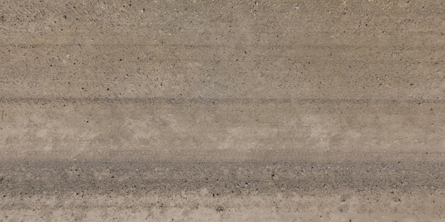 Panorama de la surface d'en haut de la route de gravier avec traces de pneus de voiture