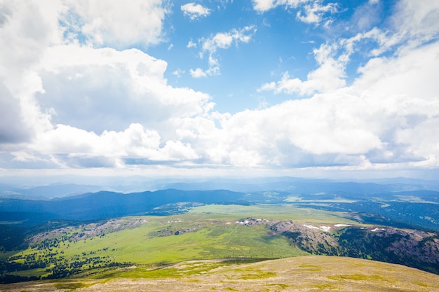 Panorama ultra large de la ligne d'horizon. Montagnes verdoyantes couvertes de forêt sur le fond de ciel bleu.