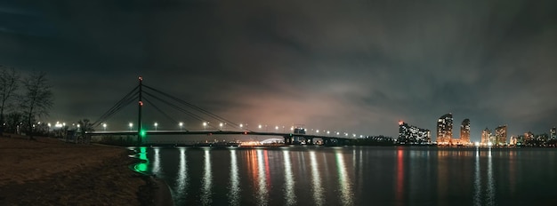 Panorama de la ville nocturne du pont nord de Kiev et du quartier d'Obolon