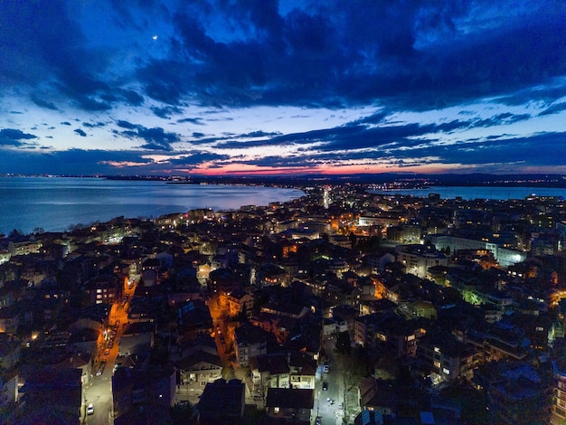 Photo panorama de la ville de pomorie avec des hôtels et des lumières baignées par la mer noire sous le ciel étoilé en bulgarie