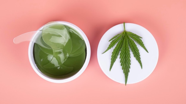 Pansements oculaires de marijuana médicale sur fond rosesoins de la peau de beauté cosmétique au cannabis