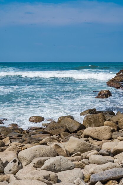 Pantai Klayar ou Klayar Beach avec des rochers et de fortes vagues contre le ciel bleu