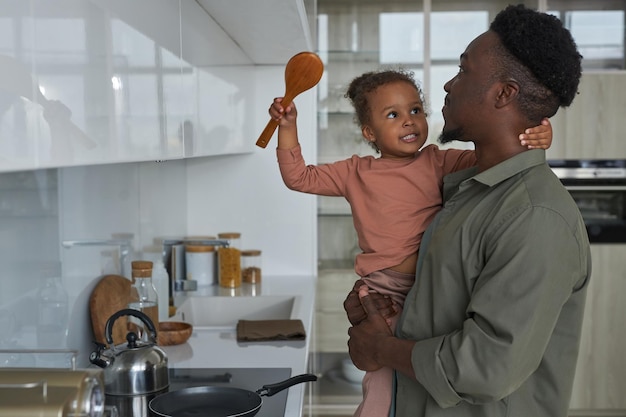 Papa afro-américain cuisinant avec sa petite fille dans la cuisine