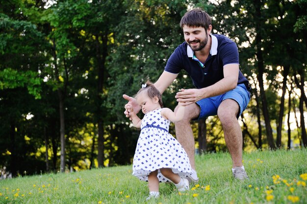 Papa aide sa fille à faire ses premiers pas