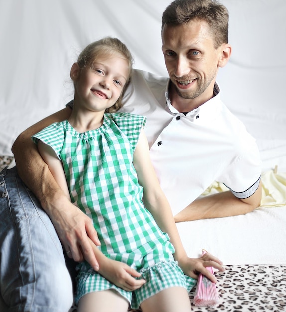 Papa aimant et une petite fille assise sur le canapé dans la pépinière