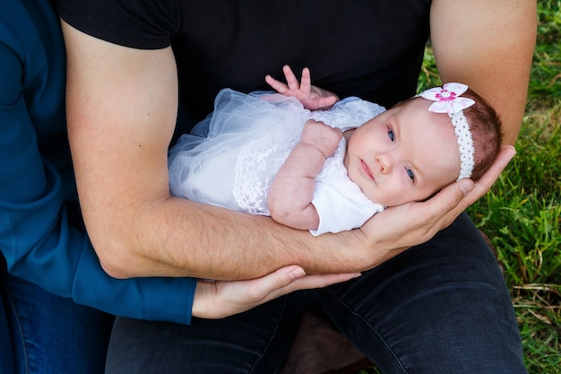 Papa aimant avec son nouveau-né sur ses bras. Beau papa avec un mignon nouveau-né endormi sur la nature à l'extérieur. La première semaine de vie de bébé. Papa heureux et famille harmonieuse.