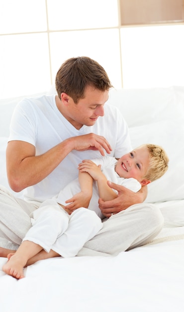 Papa animé et son petit garçon jouant sur un lit