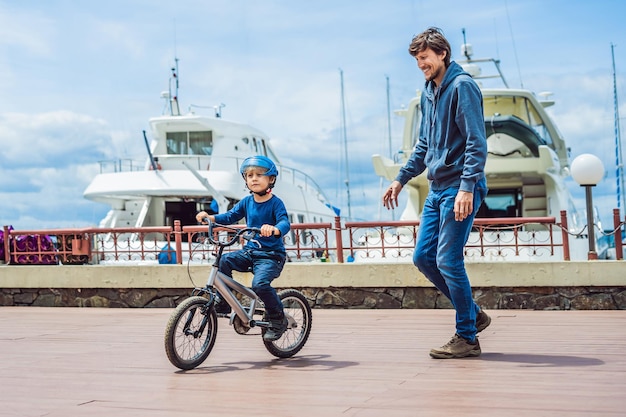 Papa apprend à son fils à faire du vélo dans le parc.