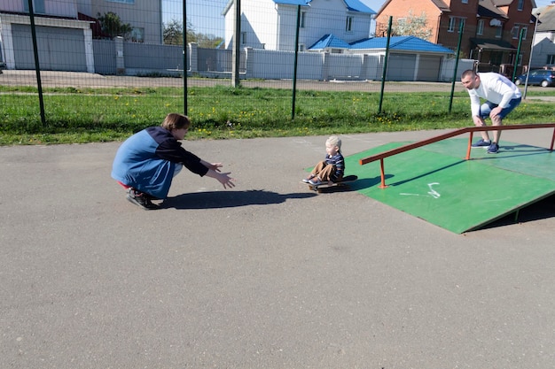 Un papa apprend à son jeune fils à faire du skateboard avec son fils aîné pendant trois ans