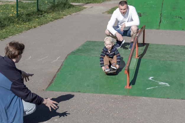Un papa apprend à son jeune fils à faire du skateboard avec son fils aîné pendant trois ans
