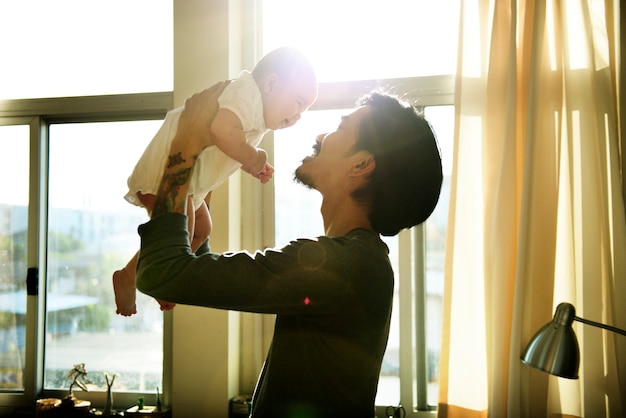 Papa asiatique tenant son bébé avec amour