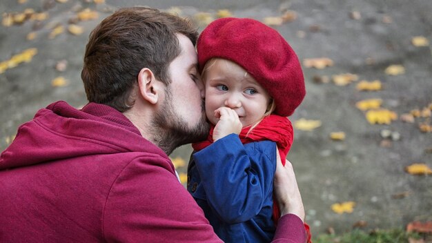 Papa embrasse sa fille qui pleure Gros plan sur l'automne