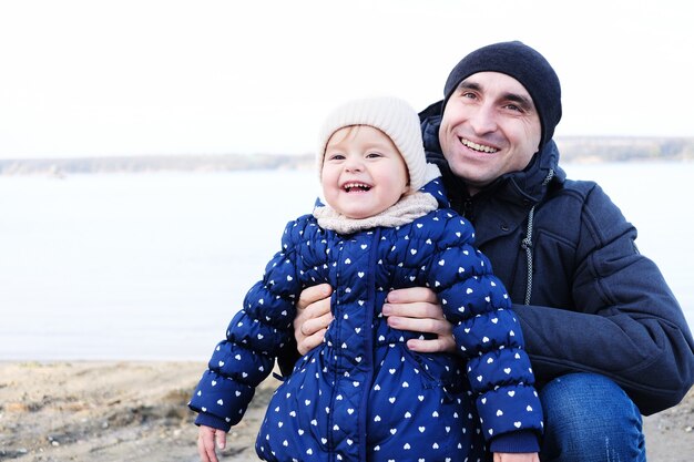 Papa embrasse sa petite fille et ils rient - Papa avec une petite fille rit sur la plage