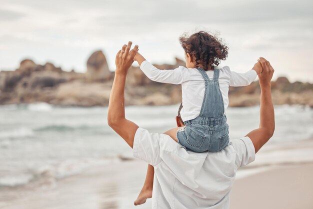 Papa et enfant de l'eau de plage en vacances en famille ensemble pour une pause estivale amusante pour créer des liens dans la nature Heureux père et enfant profitent de vacances à l'océan avec une jeune fille tenant un parent pour l'équilibre sur les épaules