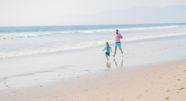 Papa et enfant garçon famille courir sur la plage d'été copie espace sport familial
