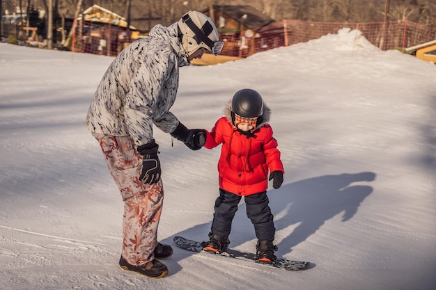 Papa enseigne le snowboard à son fils Activités pour enfants en hiver Sports d'hiver pour enfants