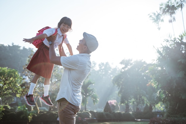 Papa fier élève sa fille vers le ciel