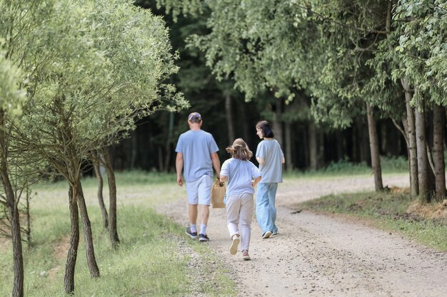 Papa et filles en promenade dans la forêt d'été