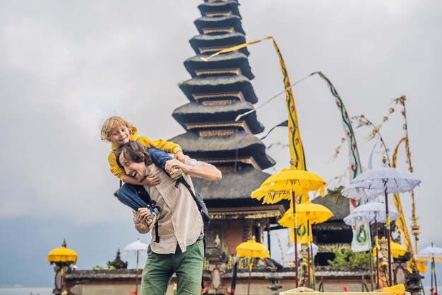 Papa et fils à l'arrière-plan de Pura Ulun Danu Bratan, Bali. Temple hindou entouré de fleurs sur le lac Bratan, Bali. Temple d'eau Shivaïte majeur à Bali, Indonésie. temple hindou. Voyager avec un enfant