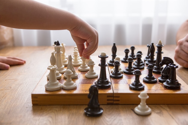 Papa et fils jouent aux échecs ensemble à la maison