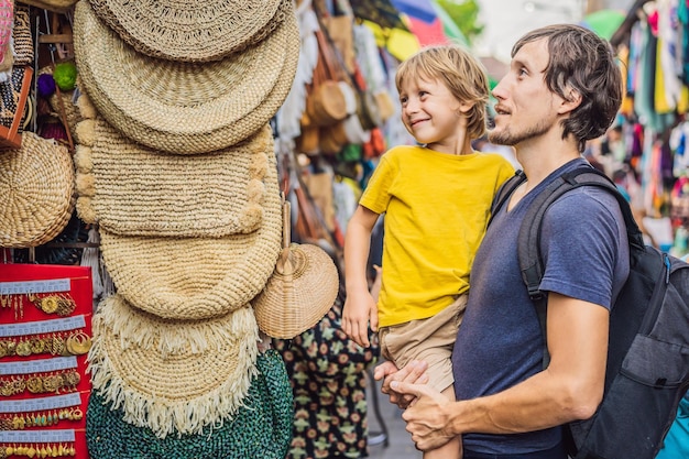 Papa et fils sur un marché à ubud bali boutique de souvenirs typique vendant des souvenirs et de l'artisanat de bali