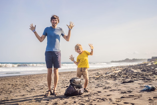 Papa et fils nettoient la plage éducation naturelle des enfants