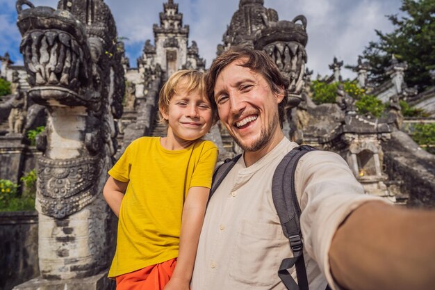 Photo papa et fils touristes sur fond de trois échelles de pierre dans le magnifique temple pura lempuyang luhur