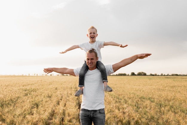 Papa et fils voyagent dans de magnifiques champs de blé.