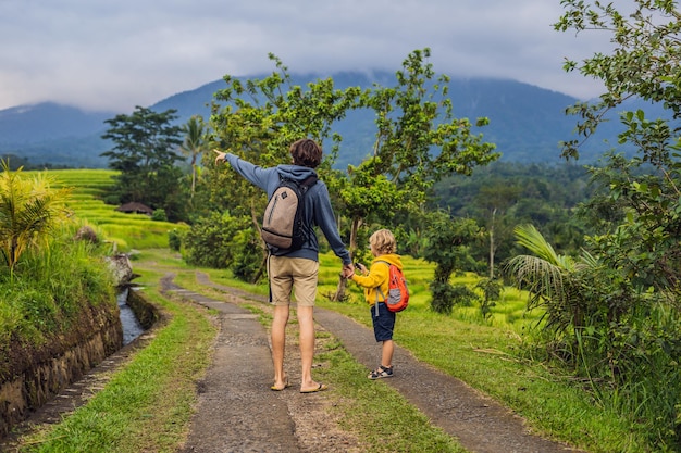 Papa et fils voyageurs sur les belles terrasses de riz de Jatiluwih sur fond de volcans célèbres à Bali, Indonésie Voyager avec des enfants concept