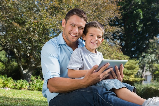 Papa heureux et fils avec une tablette pc