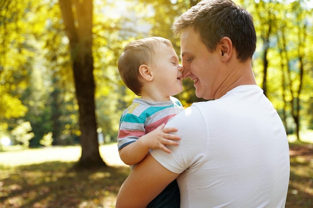 Papa joue avec son petit fils dans le jardin à l'extérieur Passe-temps familial Gens souriants heureux Garçon d'un an et demi Tout-petit Mise au point sélective