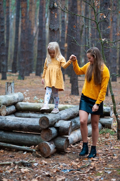 Papa et maman avec leur fille se promènent à l'automne dans la forêt Famille dans la nature