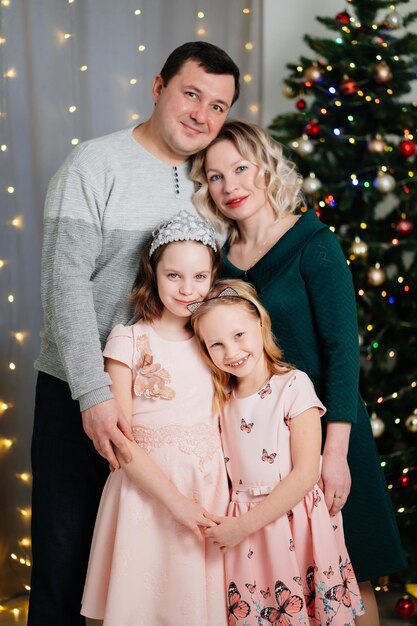 Papa maman et ses deux filles devant le sapin de Noël