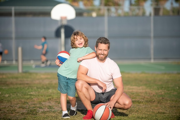 Papa et petit garçon tiennent une balle de sport. enfant joue au basket. enfance et paternité